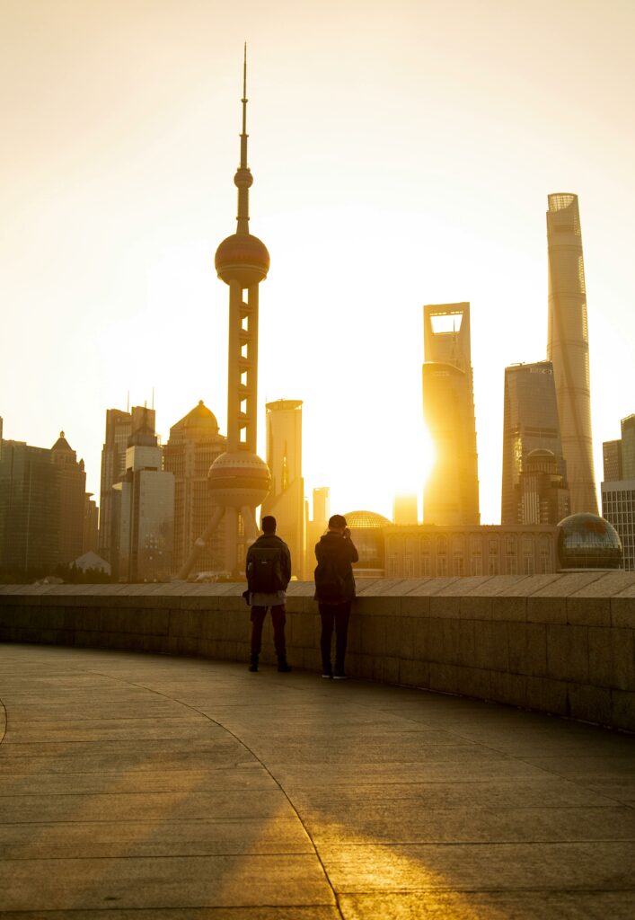 Deux personnes regardant le lever du soleil devant le Bund de Shanghai.