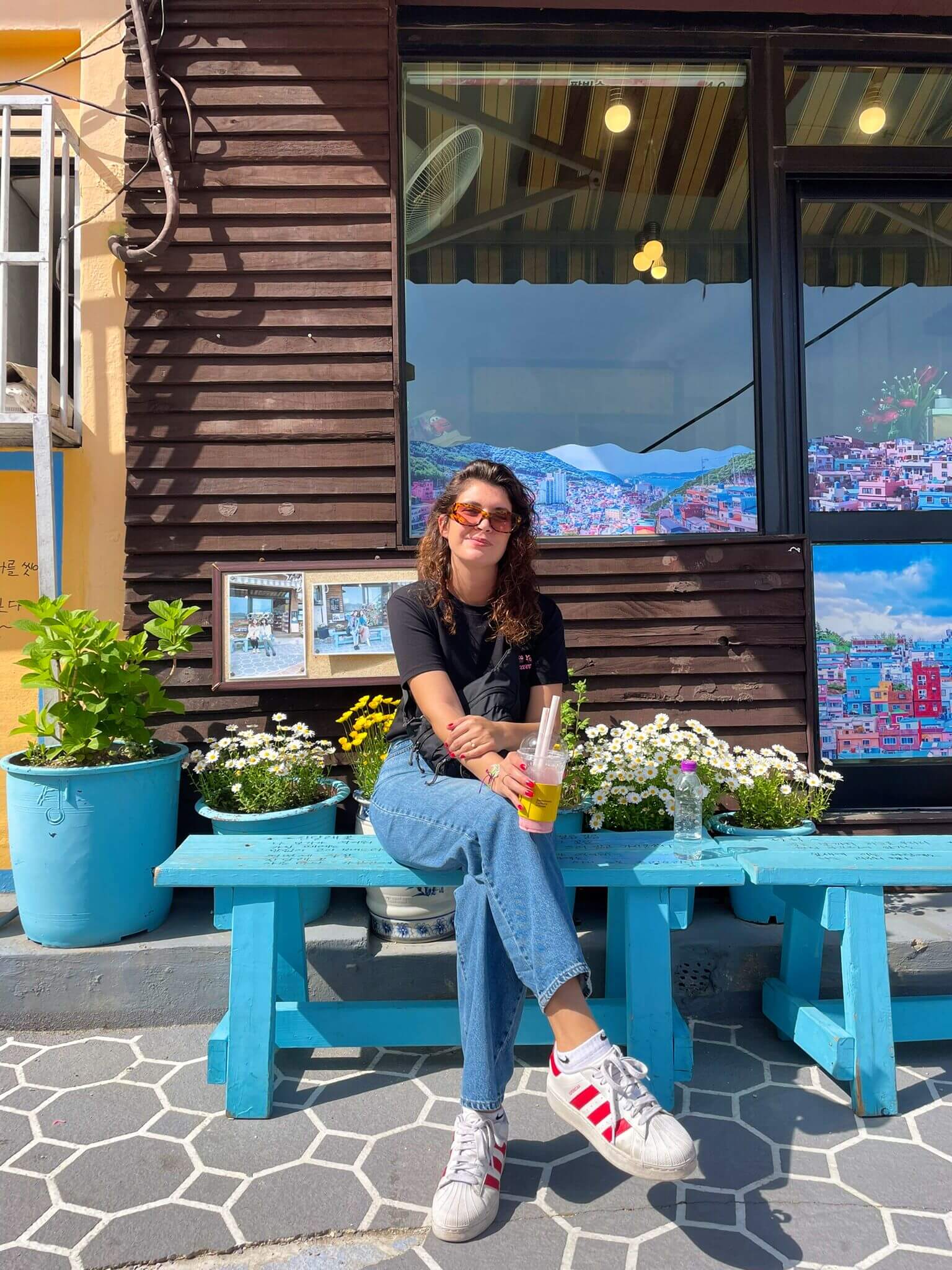 Julie, l'organisatrice de voyages en Asie, assise sur un banc au Gamcheon Culture Village de Busan.