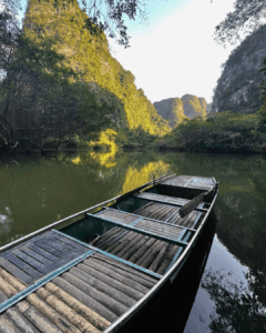 Une barque typique de Trang An au milieu du paysage karstique de la région.